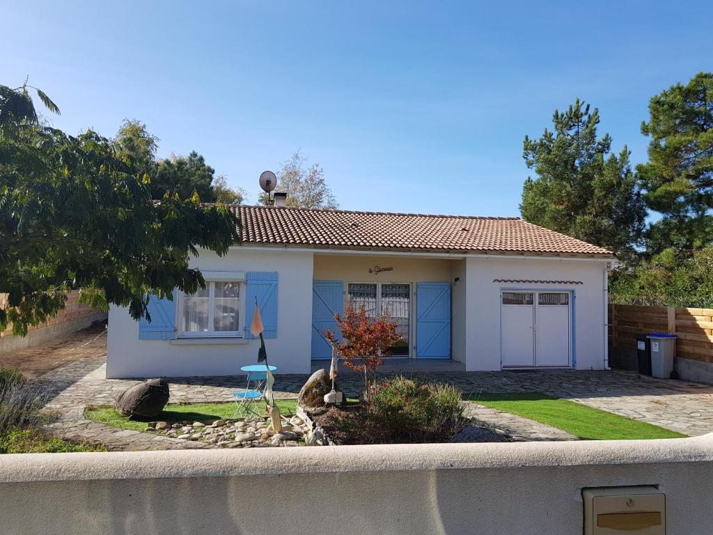 une petite maison blanche avec des portes bleues dans l'établissement Maison rénovée avec jardin, près de la plage, parking, pour 4-6 personnes - FR-1-194-96, à La Tranche-sur-Mer