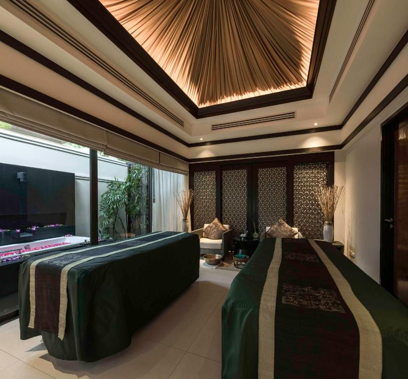 a room with a bed in a room with a ceiling at Banyan Tree Samui in Lamai