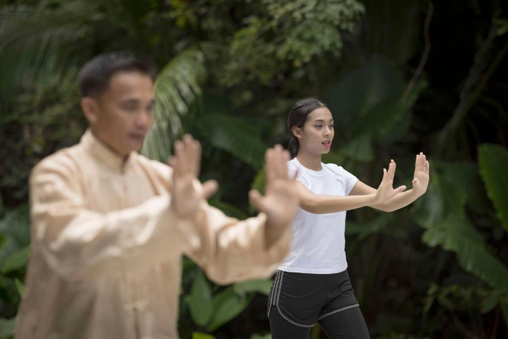 a man and a woman standing with their hands up at Banyan Tree Samui in Lamai