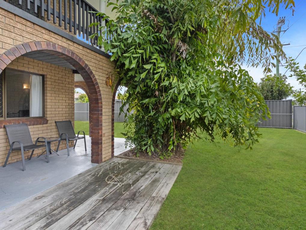 a tree in a yard next to a house at Spacious 3-Bed Home with Large Balcony in Hervey Bay