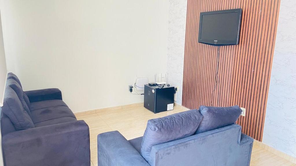 a living room with a couch and a tv at Não reservar Estou tentando tirar da plataforma in Santa Rita do Sapucaí