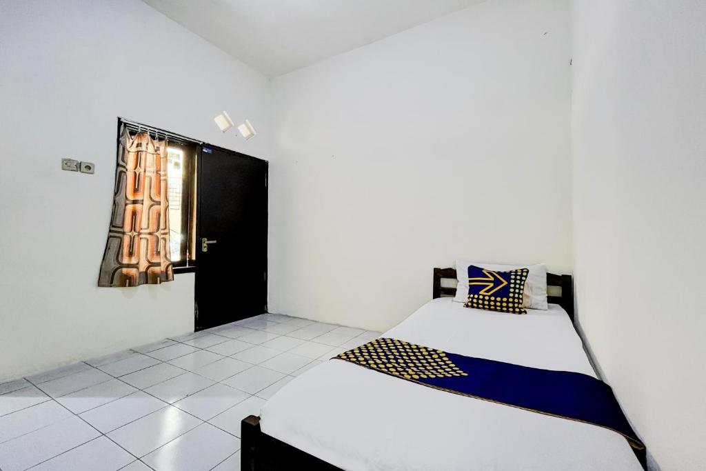a bedroom with a bed and a window in a room at OYO Life 93398 Sudimoro Guest House Syariah in Blimbing