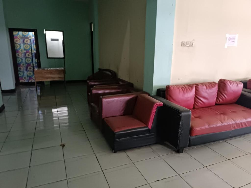 een wachtkamer met leren banken en stoelen bij Hotel O Pondok Kula Rumbih Syariah in Sungairasau