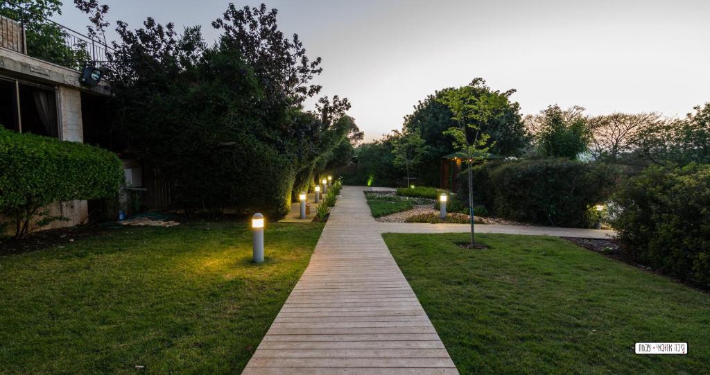 uma passarela num jardim com luzes acesas em Mul Hayar em Bet Leẖem HaGelilit
