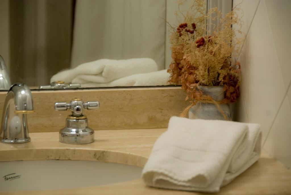 a bathroom sink with a mirror and a towel at Bagu Villa de Mar in Punta del Este