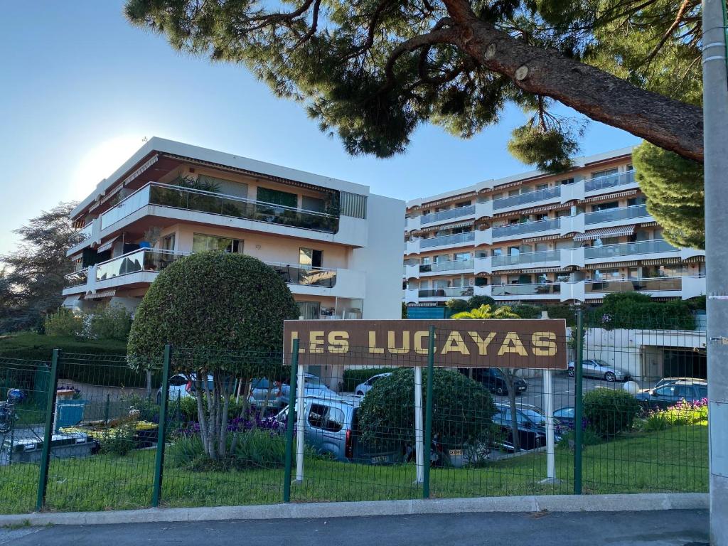 un panneau sur une clôture devant un bâtiment dans l'établissement Appartement lumineux et climatisé, face au parc privé et à 10 mins de la plage, à Cagnes-sur-Mer