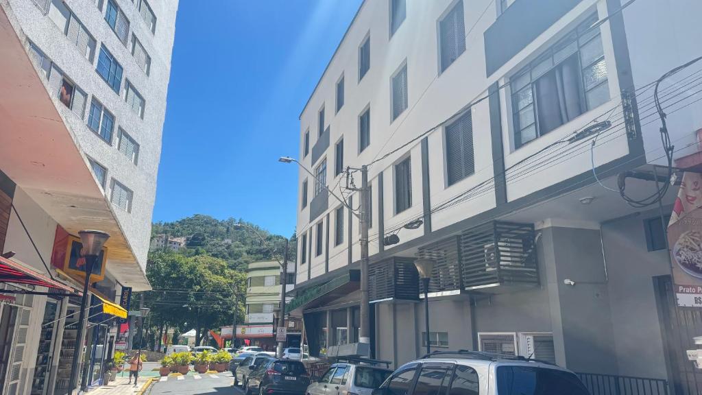 a city street with cars parked in front of a building at Apartamento Pé na Praça Centro Serra Neg in Serra Negra