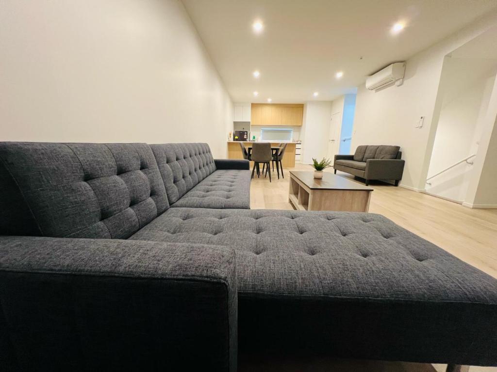 a living room with a couch and a table at Lower Hutt Central Brand New 3 bedroom 2 Bath Spacious House Balcony Private garage in Lower Hutt