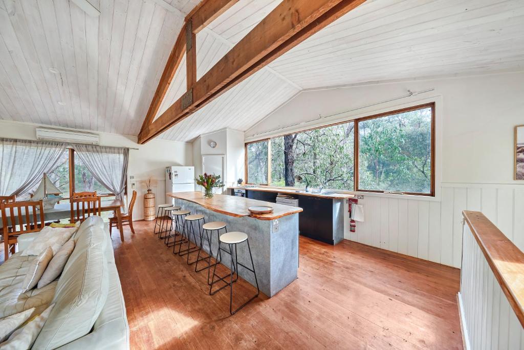 una cucina e un soggiorno con divano e tavolo di Rustic Treehouse - Aireys Inlet ad Aireys Inlet