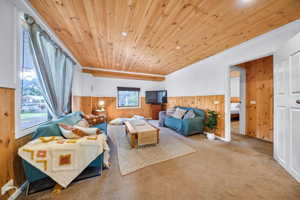 un soggiorno con pannelli in legno e soffitto in legno di Rustic Treehouse - Aireys Inlet ad Aireys Inlet