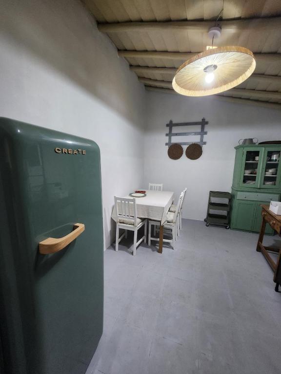 a dining room with a table and a green refrigerator at Baleizão AL in Baleizão