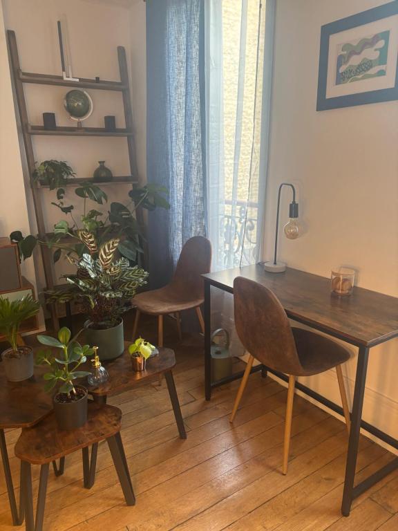 une salle à manger avec une table, des chaises et des plantes dans l'établissement Grand appartement à Paris - Porte de Versailles, à Issy-les-Moulineaux