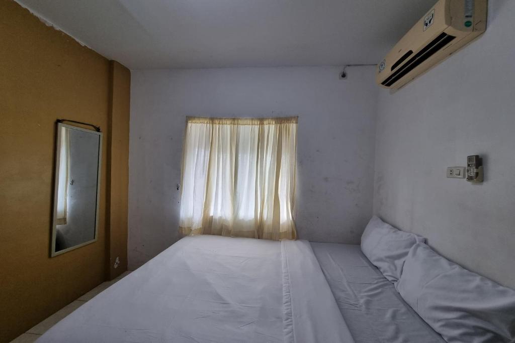 a small room with two beds and a window at Hotel O Wira Residensia Syariah in Medan
