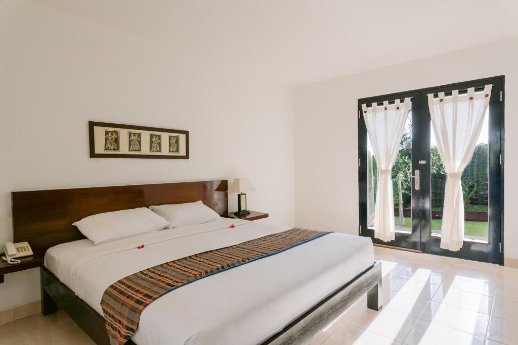 Postel nebo postele na pokoji v ubytování Legong Keraton Beach Hotel