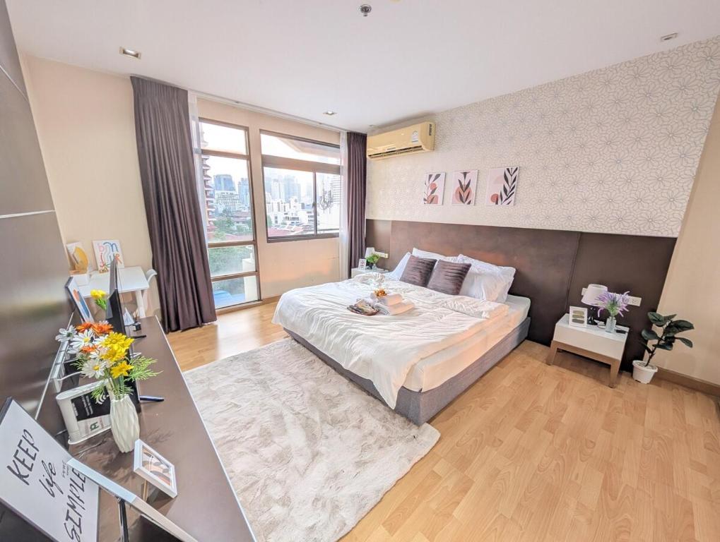 een slaapkamer met een groot bed en een groot raam bij Executive Suite 1BR and Sofa Bed 150m to Nana BTS in Bangkok