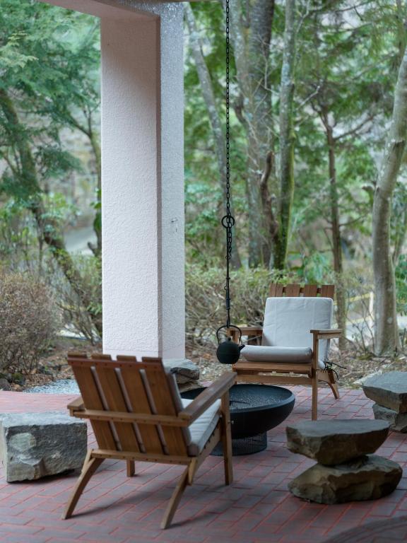 a porch with two chairs and a swing at Private Villa 3 minutes from bus stop - in the meantime in Hakone