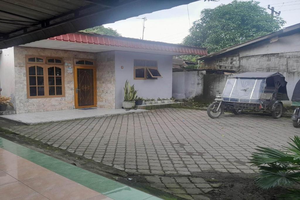 a house with a motorcycle parked in front of it at Hotel O Kamboja Homestay Syariah in Delitua