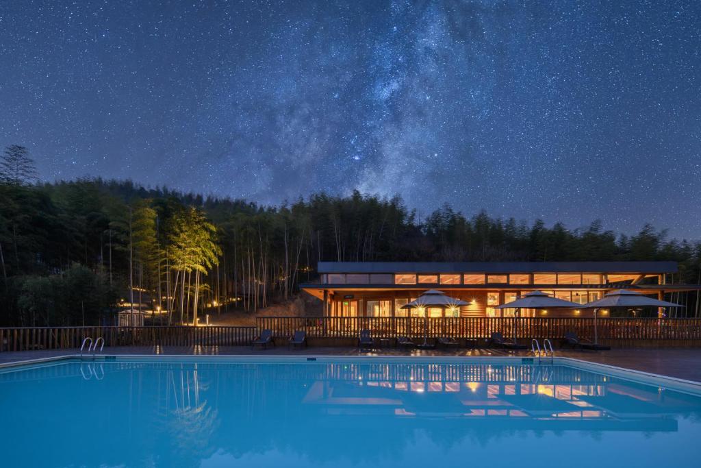 a resort with a swimming pool at night at Xiang Yue Lake International Resort in Deqing