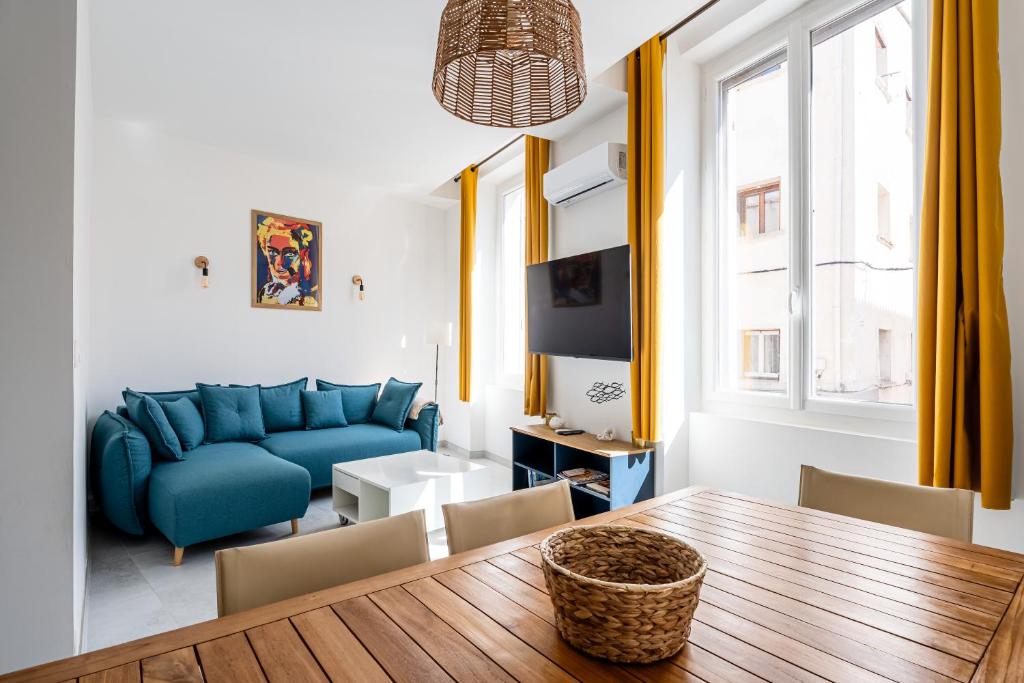 un salon avec un canapé bleu et une table dans l'établissement L'Icare par Dodo à Cassis, à Cassis