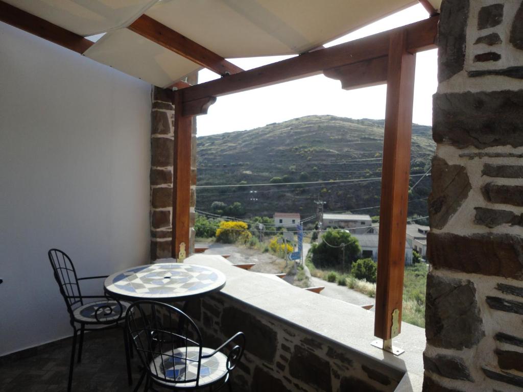 a balcony with a table and chairs and a view at The Castle's Key in Volissos