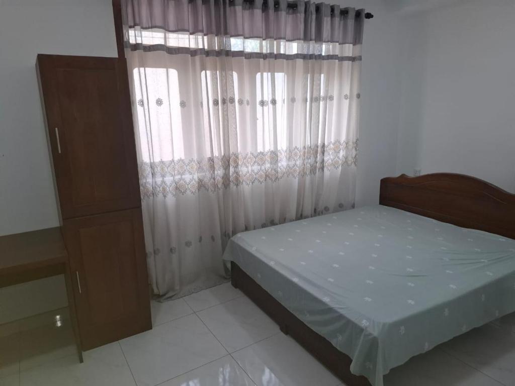 a small bedroom with a bed and a window at Plus in Negombo