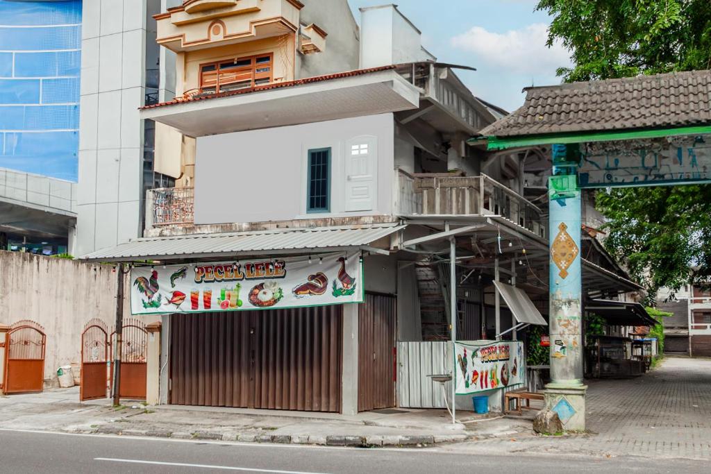 un bâtiment avec une enseigne sur le côté d'une rue dans l'établissement Hotel O Wongso Residence Syariah, à Pangkal Pinang