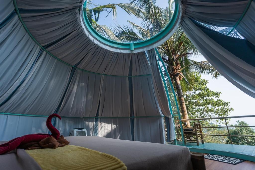 a bedroom with a tent with a stuffed animal on a bed at Leela Garden Resort Bubble house in Ban Nok