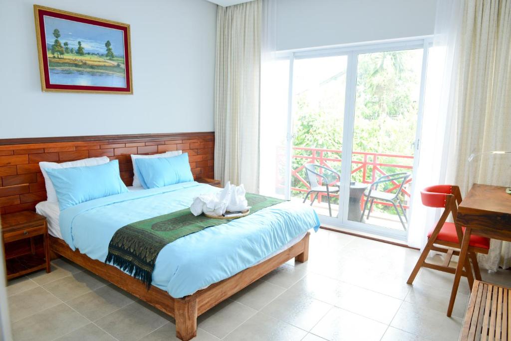 ein Schlafzimmer mit einem Bett und einem Balkon in der Unterkunft Mowin Boutique Hotel & Residence in Phnom Penh
