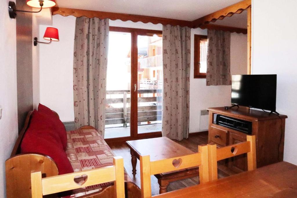 un salon avec une télévision et une table avec une table dans l'établissement Résidence Les Eglantines - B216 LES EGLANTINES LES ORRES 1800 MAE-1194, aux Orres