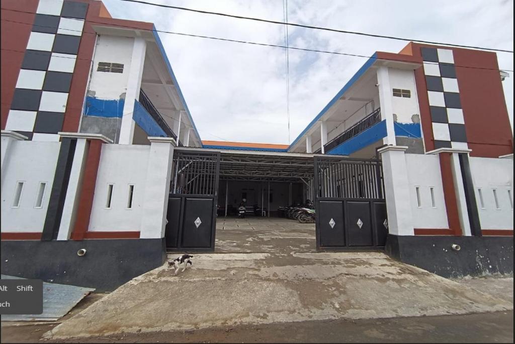 a building with a dog standing in front of it at OYO 93774 Khaira Kos Dan PenginapanNearYani Heahlerr in Rantau