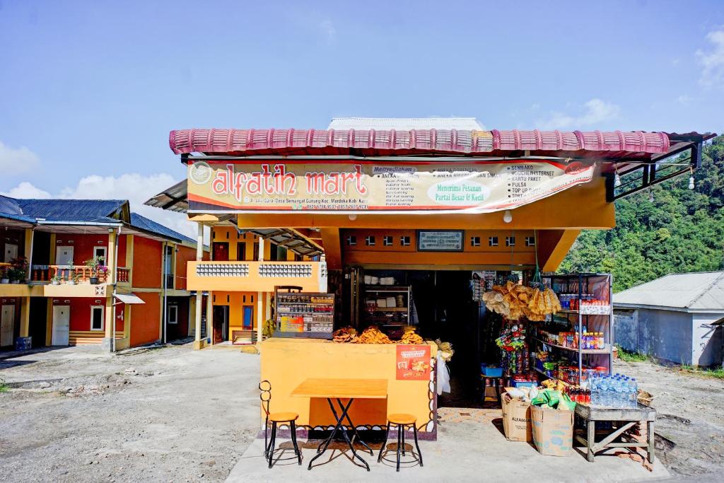 un negozio con tavolo e sedie di fronte di Hotel O Sejolie Sibayak a Berastagi