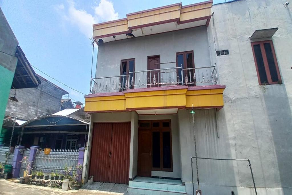 a building with a balcony on top of it at Hotel O 45 Guest House in Sragen