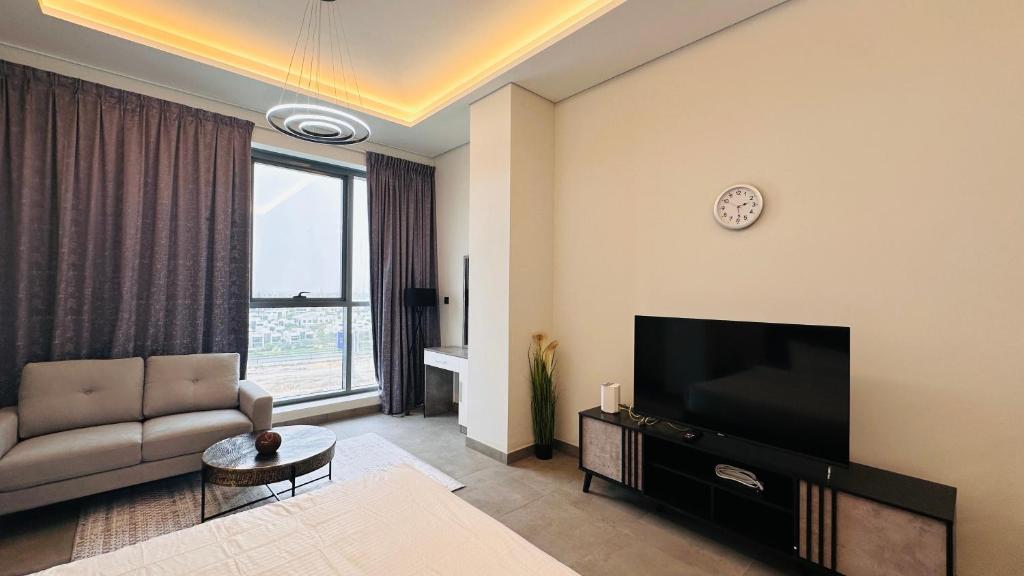 a living room with a couch and a television at Spacious Studio Apartment Palm View with Big Balcony Free Parking by Belvilla in Dubai