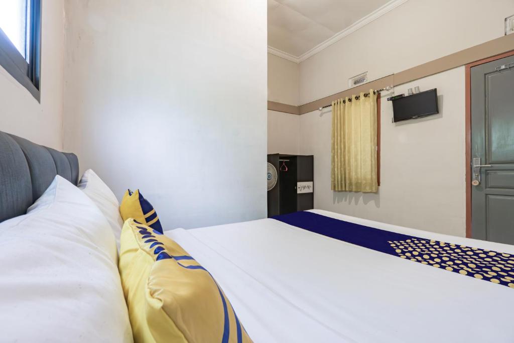 a bedroom with a bed with white and blue sheets at Hotel O 3n Homestay Syariah in Sidoarjo