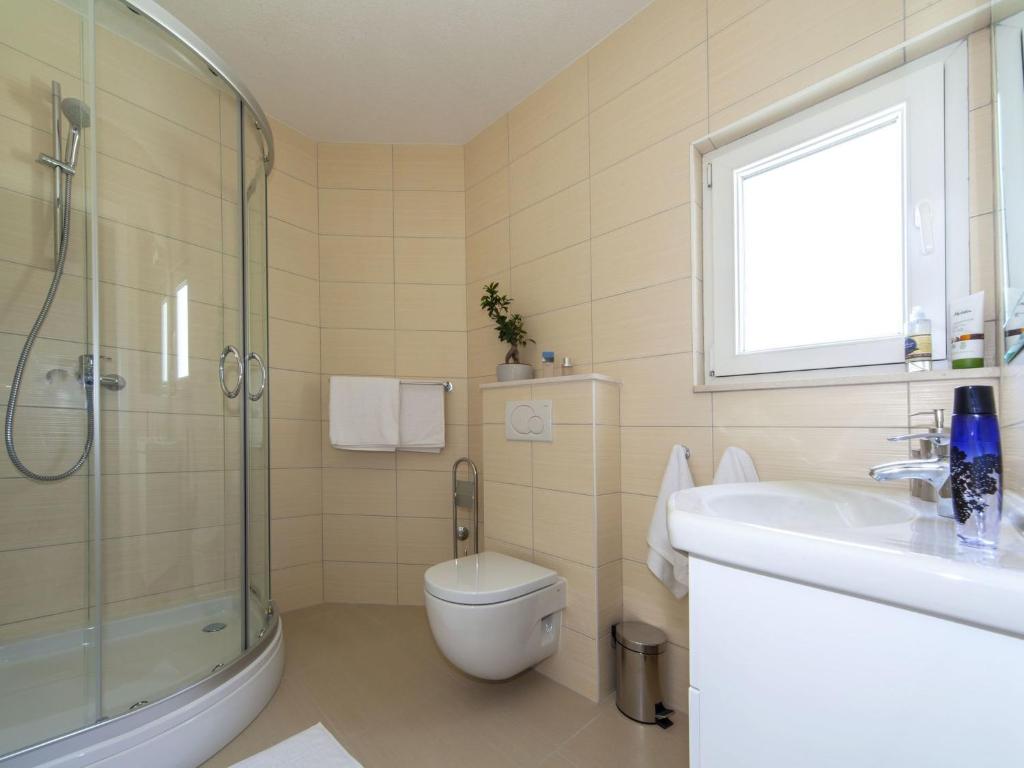 a bathroom with a toilet and a sink and a shower at Modern Villa in Povlja with Pool in Povlja