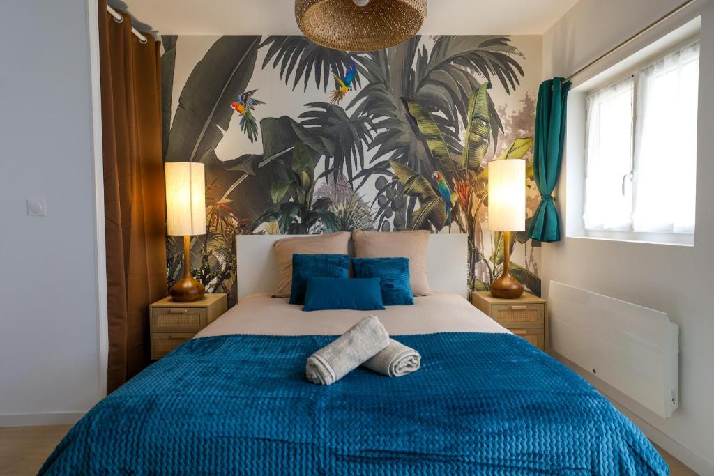 une chambre avec un lit bleu et blanc avec des oreillers bleus dans l'établissement Jungle Cruise #200m François 1er, à Cognac