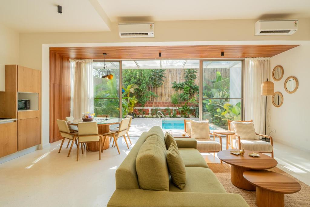 a living room with a couch and a table at ELIVAAS Mirai Leo - 3 BHK Villa Near Vagator Beach With Pool in Vagator