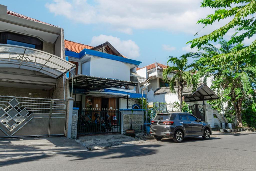 une voiture garée devant une maison dans l'établissement OYO Life 93978 Wisma Homestay Syariah, à Surabaya