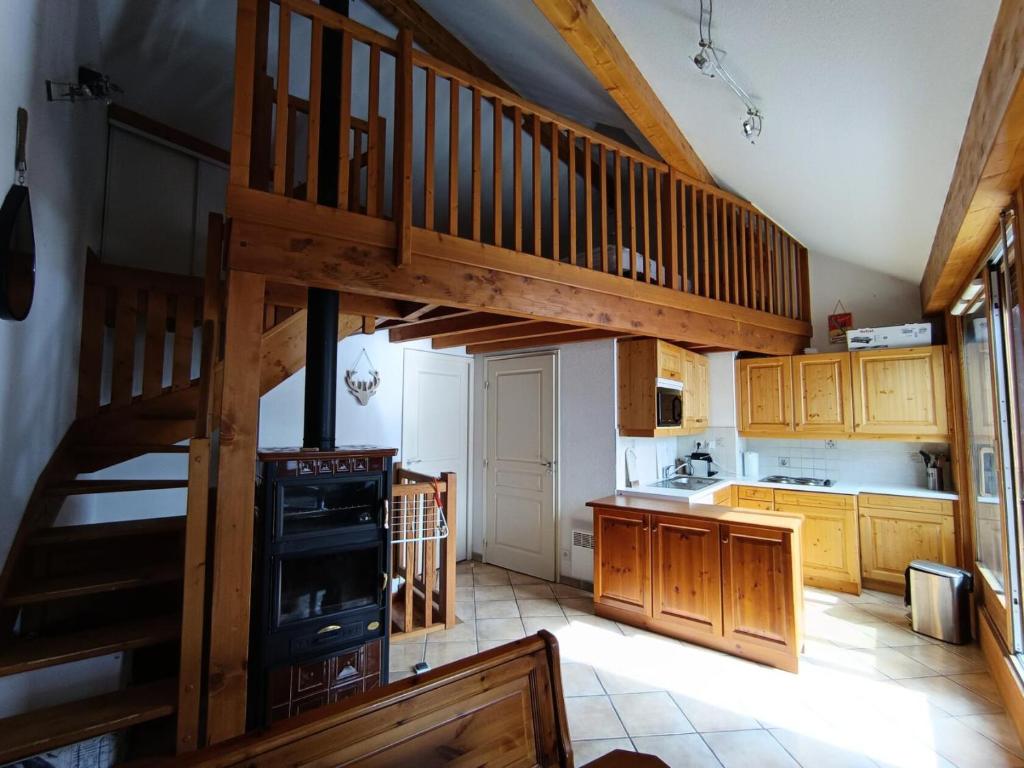 une cuisine avec un escalier en bois dans une maison dans l'établissement Résidence Palathium - Grand appartement duplex pour 4 à 6 personnes - Terrasse TROPEZIENNE plein sud - Vue pistes. MAE-8354, à Montgenèvre