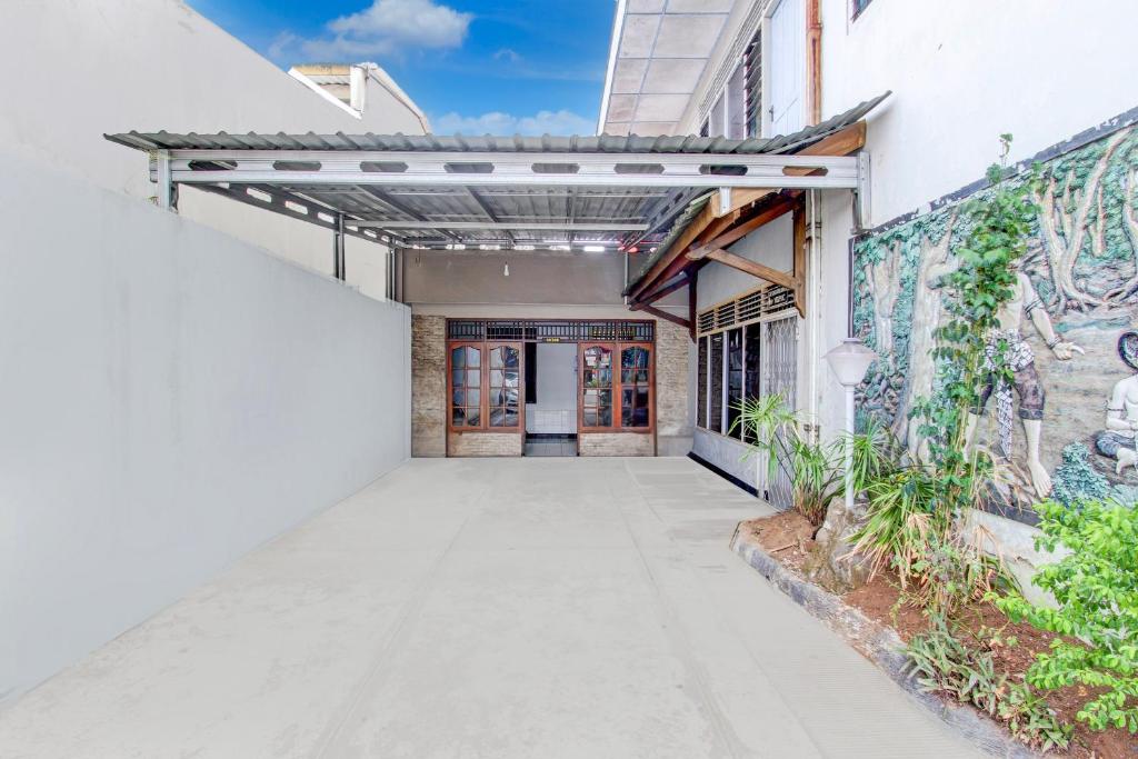 an alleyway leading to a building with graffiti at Hotel O Agung in Purwokerto