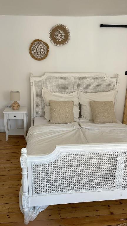 a white bed with pillows on it in a room at Fachwerkstube in Witzenhausen