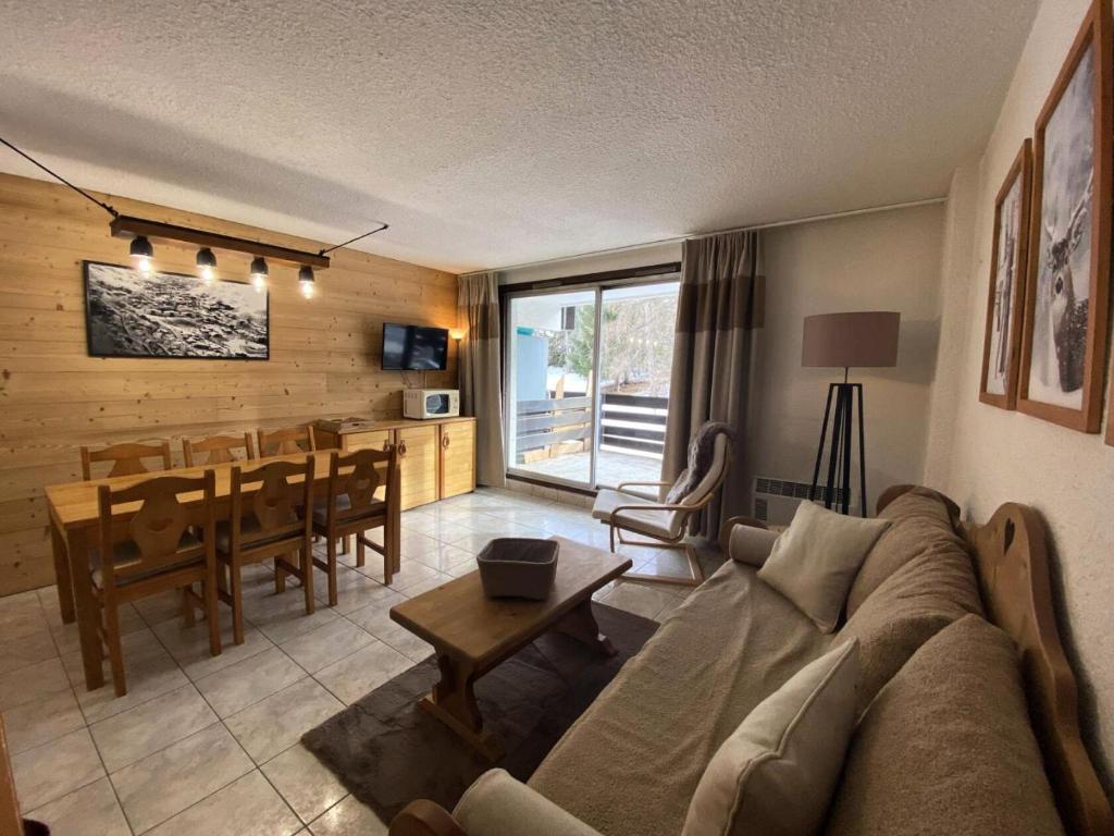 un salon avec un canapé et une salle à manger dans l'établissement Résidence Prapelier - Appartement chaleureux style montagne, situé dans un secteur calme au pied des pistes MAE-5501, à Vénosc