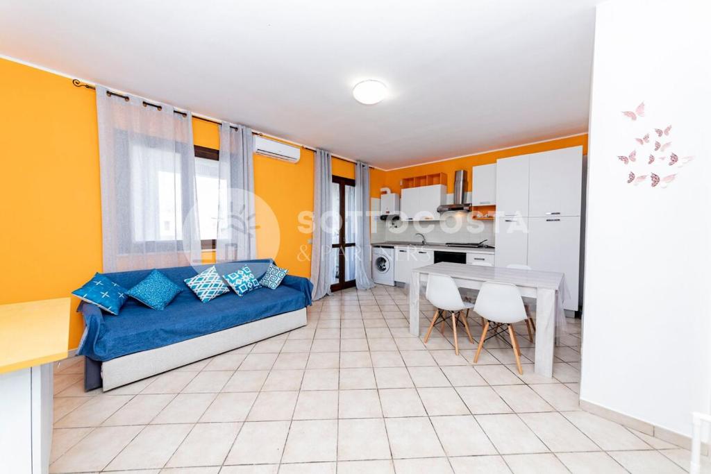 a living room with a blue couch and a table at Alice Flat - SAN FOCA in San Foca