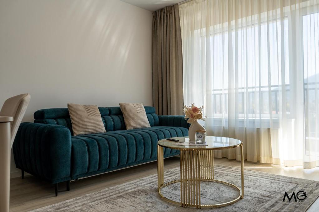 un soggiorno con un divano blu e un tavolo di MoHost Noua 3 - Premium Escape with Balcony Views a Braşov