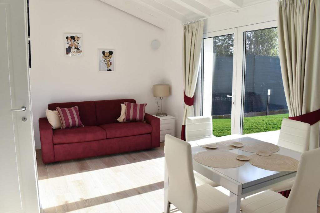 a living room with a red couch and a table at Renovated villa 400 meters from the sea with garden in Forte dei Marmi
