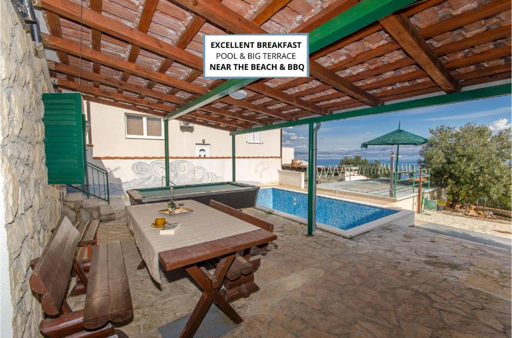 a patio with a table and a pool and a sign at Apartments Laguna in Stomorska