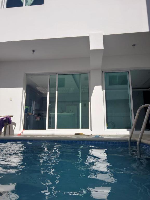 a swimming pool in front of a house at Villa Muñoz in San Felipe de Puerto Plata
