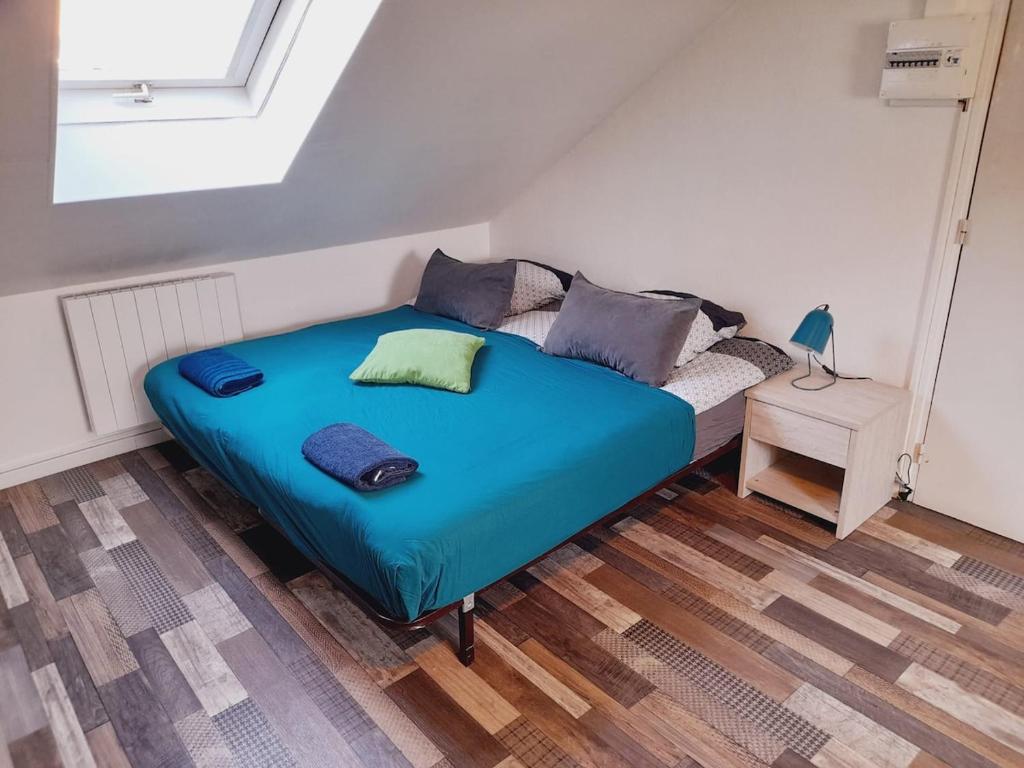 - une chambre avec un lit bleu et un canapé dans l'établissement Chez Dogoré, à Reims