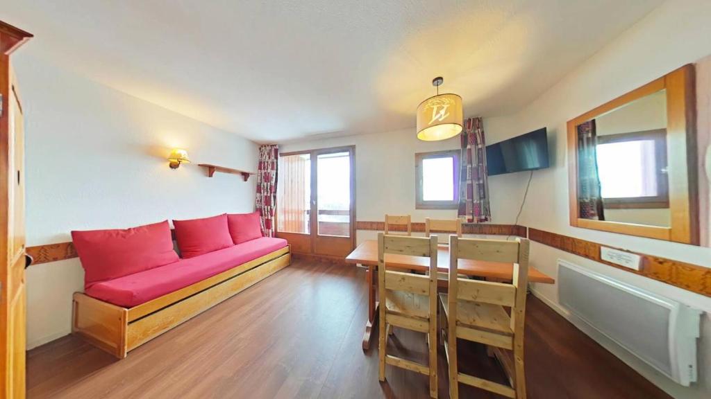 un salon avec un canapé rouge et une table dans l'établissement Résidence Le Cervin - Résidence LE CERVIN N°304 MAE-5551, à La Plagne Tarentaise