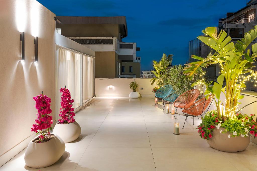 un balcone con fiori e sedie su un edificio di Elysium Boutique Apartments - Catania a Catania